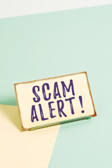 Text sign showing Scam Alert. Business photo showcasing fraudulently obtain money from victim by persuading him Paper placed tilted above buffer wire on soft pastel multi colours backdrop