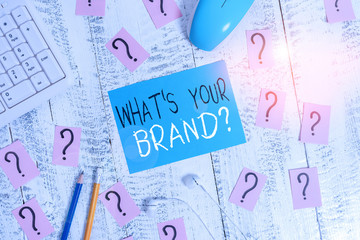 Text sign showing What S Your Brand Question. Business photo text asking about product logo does or what you communicate Writing tools, computer stuff and scribbled paper on top of wooden table