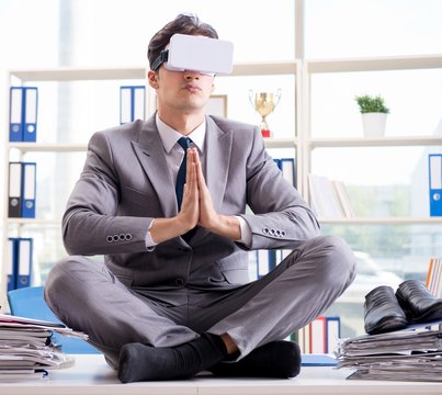 Businessman with VR virtual reality glasses in office