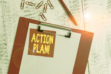 Fototapeta premium Word writing text Action Plan. Business photo showcasing proposed strategy or course of actions for certain time Clipboard paper sheet sticky note ballpoint clips vintage wooden background