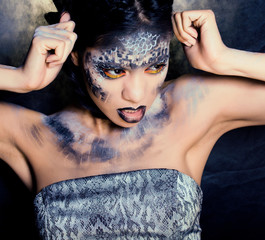 fashion portrait of pretty young woman with creative make up like a snake, halloween concept