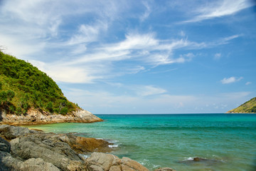 Fototapeta na wymiar A beach with large stones, the sea and green hills.