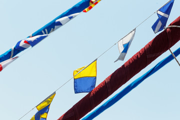 Obraz premium Sea holiday flags are pulled over the yards of a snow-white yacht