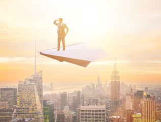 Fototapeta na wymiar Businessman flying on paper plane in business concept