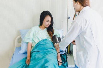 Obraz premium Asian women doctors come to measure the patient's pressure. Lying in the patient's bed