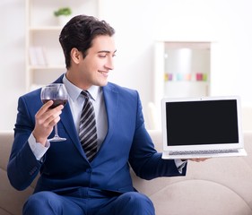 Businessman drinking wine sitting at home