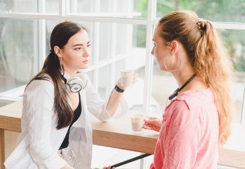 Two beautiful young women drinking coffee and talking together. concept of relaxation.