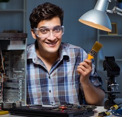 Computer repair man cleaning dust with brush