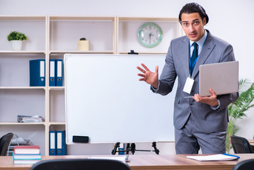 Young businessman standing in front of white board