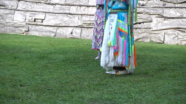 Native American First Nations Indian Metis Standing Around Talking By Log Home Teepee On Green Grass In Summer