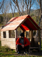 Fototapeta premium Man in small wooden house in the forest