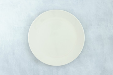 Empty black plate on dark stone background.