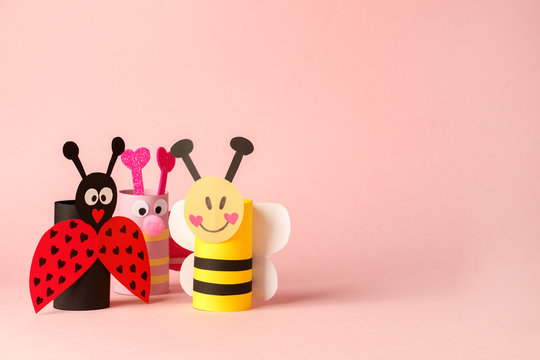 Paper toy ladybug, bee, butterfly for valentine romance party. Easy crafts for kids on pink background, copy space, die creative idea from toilet tube roll, recycle reuse eco concept