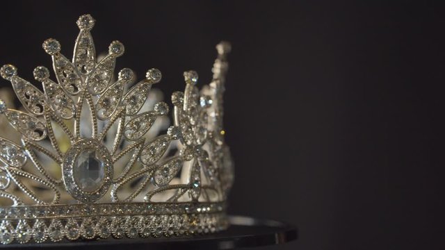 Beauty pageant, bride's or queen's crown on a turning display as in a museum, illuminated with black background