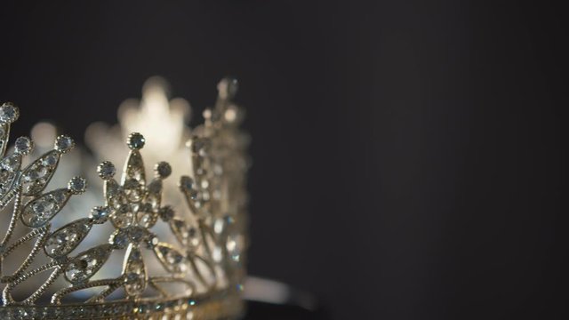 Beauty queen, Miss Pageant or bride's crown of diamond and silver on a turning display with black bacground and copy space - isolated close up