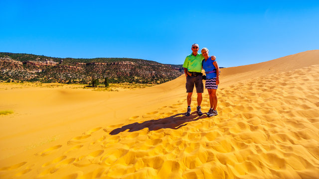 Active Senior Couple Hiking The Sand Dunes In The Coral Pink Sand Dunes State Park Along Vermilion Cliffs In Kanab County In Utah, United States