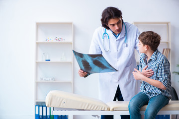 Obraz premium Male radiologist looking at boy's images