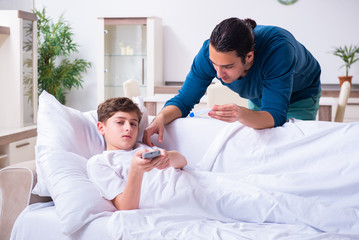 Fototapeta premium Young father caring for sick son