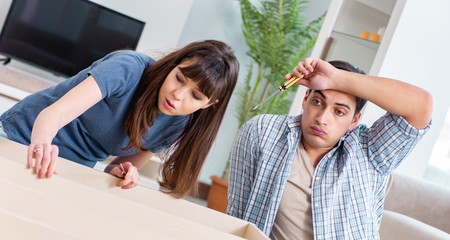 Young family assembling furniture at new house
