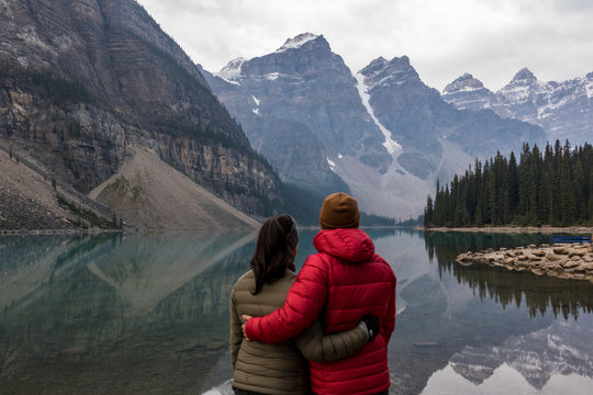 Couple Looking Out Over A Lake In The Mountains