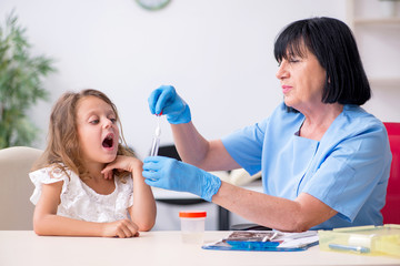 Little girl visiting old female doctor