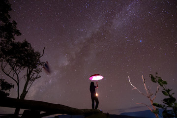 milky way in night sky with woman standing in background