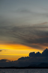 Sunset background and sun beam on the open sea with beautiful clouds.