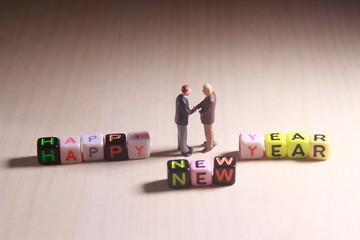 Dramatic Lighting Simple Photo, Mini Figure Businessman Toy, Handshaking with Happy New Year Word...