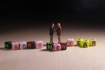 Dramatic Lighting Simple Photo, Mini Figure Businessman Toy, Handshaking with Happy New Year Word...