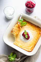Cottage cheese baked pudding with natural yogurt or sour cream, red berry jam and mint. Healthy breakfast. 
