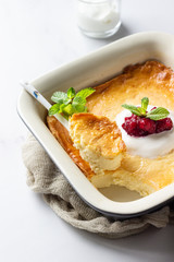 Cottage cheese baked pudding with natural yogurt or sour cream, red berry jam and mint. Healthy breakfast. 