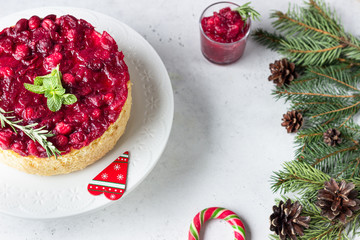 Classical New York cheesecake with cranberry sauce, mint and rosemary, light grey stone background....