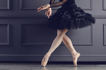 Legs of a ballerina on a black background.