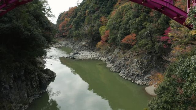 Flying along Echi River towards Eigenji, Slow tilt to reveal bottom of Red Iron Bridge, Japan