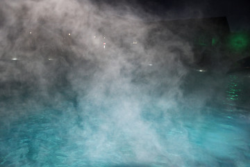 Pure clear water in the thermal pool. Hot water flows and fog rises above the pool, steam. Blue...