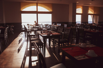 Shallow depth of field (selective focus) image with tables in a restaurant at breakfast early in the morning