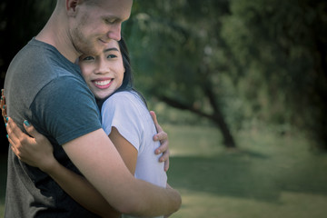 Obraz premium Happy valentine day, young couple hugging together in the park.