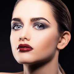 Cute glamour fashion model woman beauty face, bright vogue style make-up, perfect skin, glossy red lips. Black background