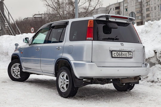 Rear view of Honda CR-V first generation in silver color after cleaning before sale in a winter day and snow background