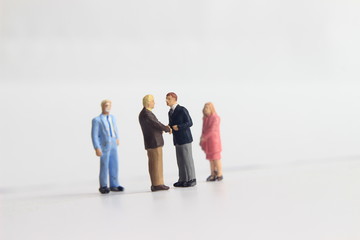 Gray Backgrond, Simple Illustration Photo for Mini Figure Two Man Toy Handshaking for Business Agreement Beyond their partner