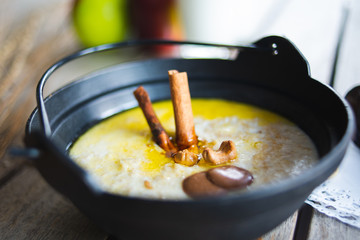 Traditional breakfast. Milk oatmeal with chocolate and granola. on a wooden table.