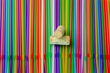 Drinking straws. Abstract background with many multi colored plastic tubules for juice or cocktail, single-use disposable. And two bottle caps in the middle.Top flat view.