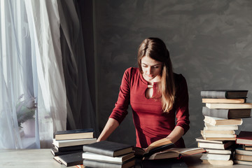 girl reads a lot of books at home