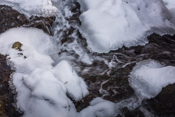 wirbelndes wasser mit eis und schnee im winter