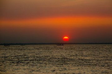 Colorful golden Sunset on Sea. Fishermans are returning home with fish, manually at sunset on Char Samarj beach at Chandpur, Bangladesh.