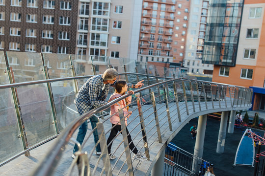 Old grandfather and grandchildren having happy time together in park, family enjoy playing together, running outdoor in outumn time vacation.