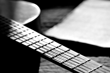 A fragment of an acoustic guitar lit by the sun. Black and white