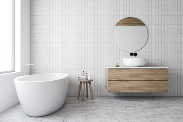 Luxury white tile bathroom, tub and round mirror