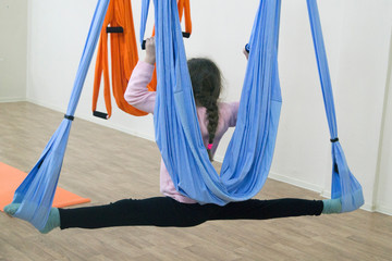 the girl is engaged in yoga on a hammock
