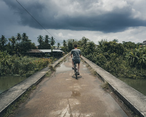 Cycling into the rain at Don Det Island 